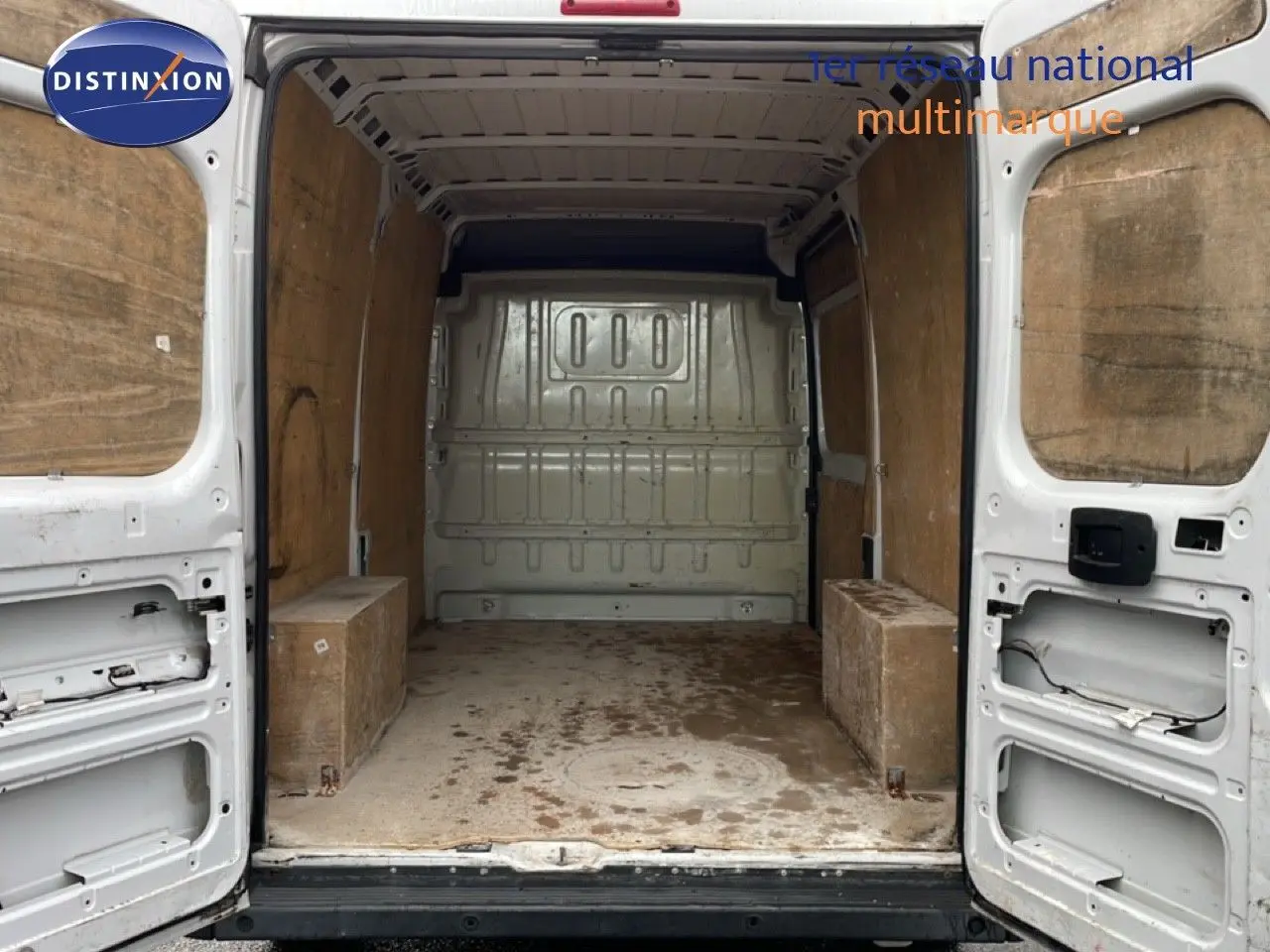 Vue arrière ouverte du fourgon blanc FIAT Ducato 2014, montrant l'espace de chargement vide avec parois en bois.