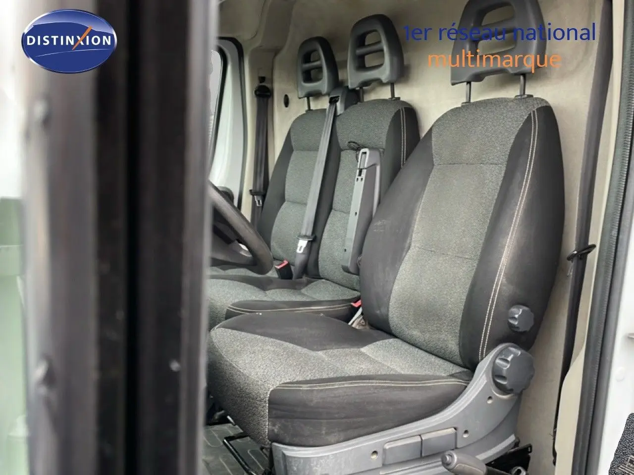 Vue intérieure côté gauche montrant les sièges gris et noirs du Fiat Ducato Fourgon blanc de 2014.