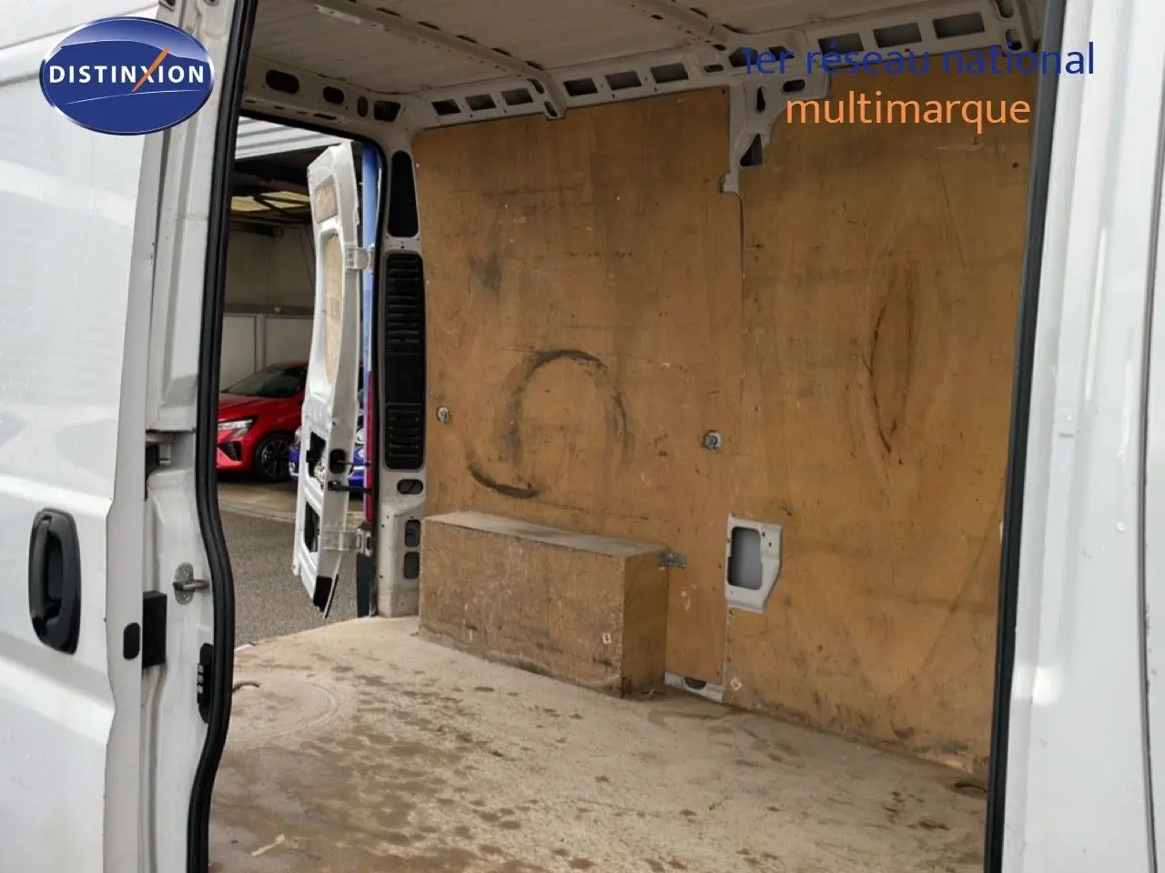 Vue arrière ouverte du FIAT Ducato Fourgon blanc de 2014, montrant l’intérieur utilitaire en bois usé.