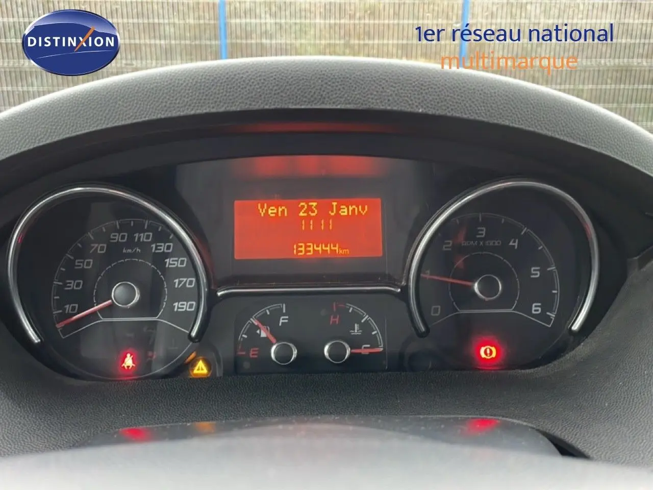 Vue rapprochée du tableau de bord du Fiat Ducato Fourgon blanc, affichant le compteur et l'odomètre à 133444 km.