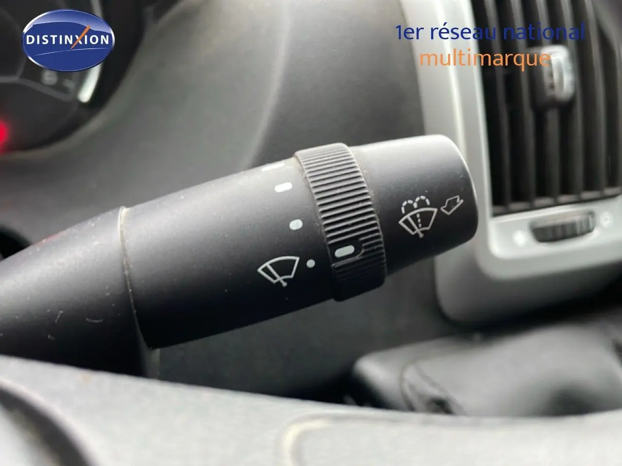 Gros plan sur la manette d’essuie-glace du tableau de bord du FIAT Ducato Fourgon blanc, version 2014.