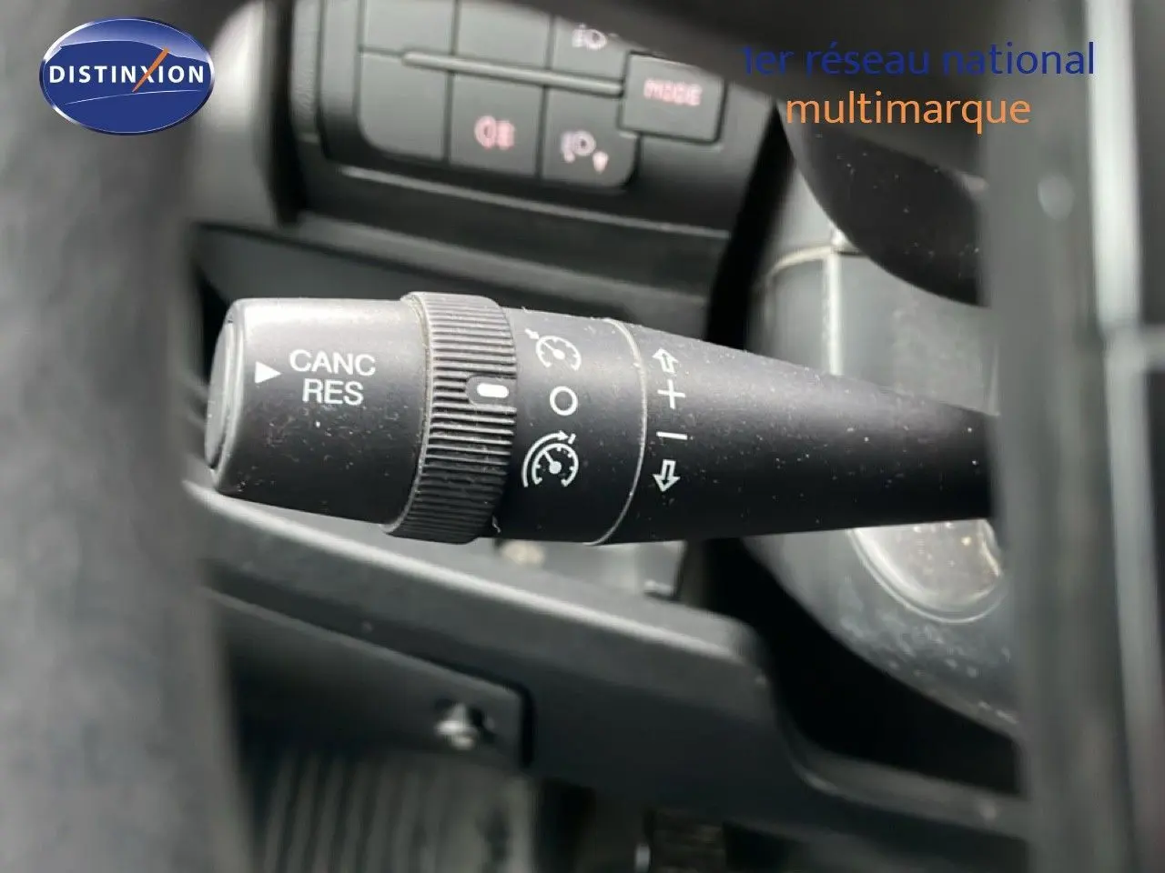 Gros plan sur la commande de régulateur de vitesse noire à gauche du volant du Fiat Ducato Fourgon blanc.