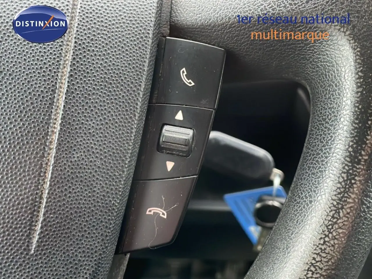 Gros plan sur les commandes téléphoniques au volant en cuir noir du Fiat Ducato Fourgon blanc, version 2014.