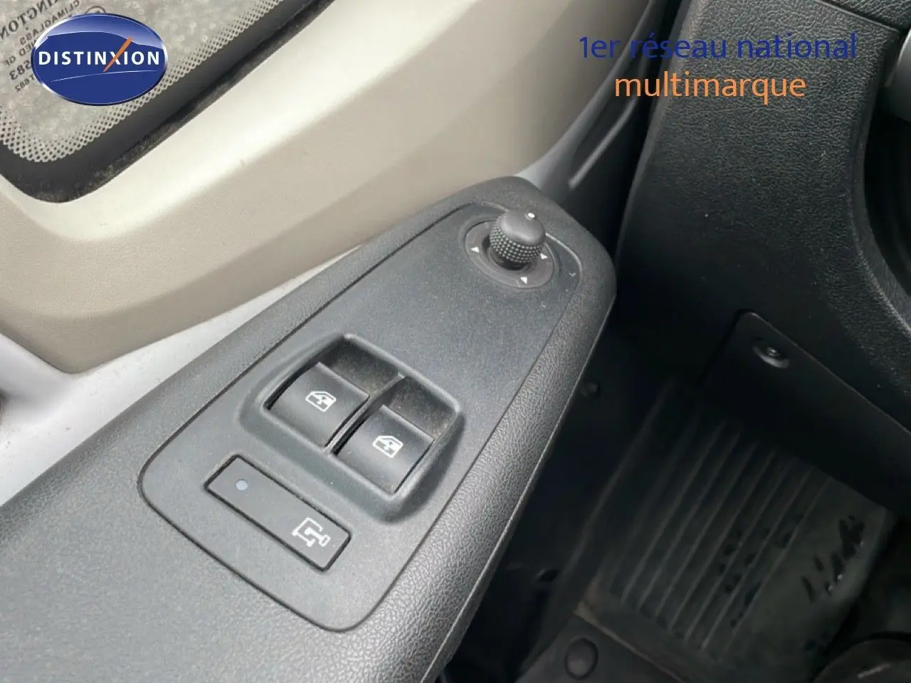 Gros plan sur la commande des vitres électriques côté conducteur d’un Fiat Ducato blanc, intérieur gris et noir.