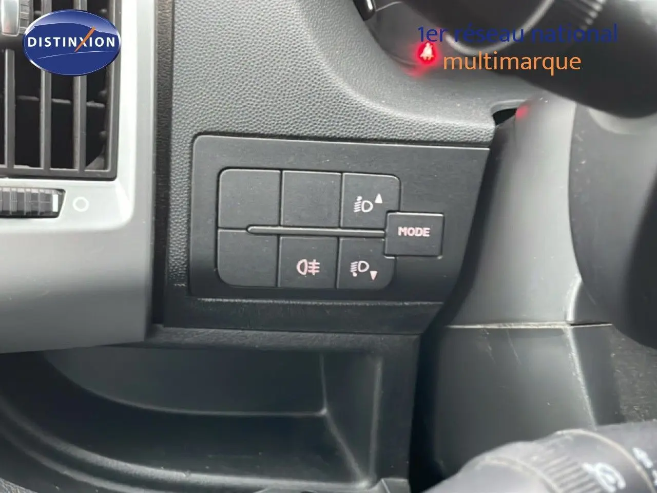 Gros plan sur les commandes d’éclairage à gauche du volant dans l’habitacle du Fiat Ducato Fourgon blanc de 2014.