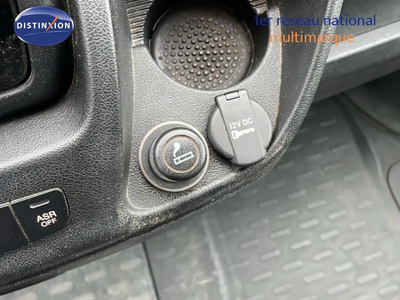 Gros plan sur la console centrale du Fiat Ducato Fourgon blanc 2014, montrant prise 12V et bouton allume-cigare.