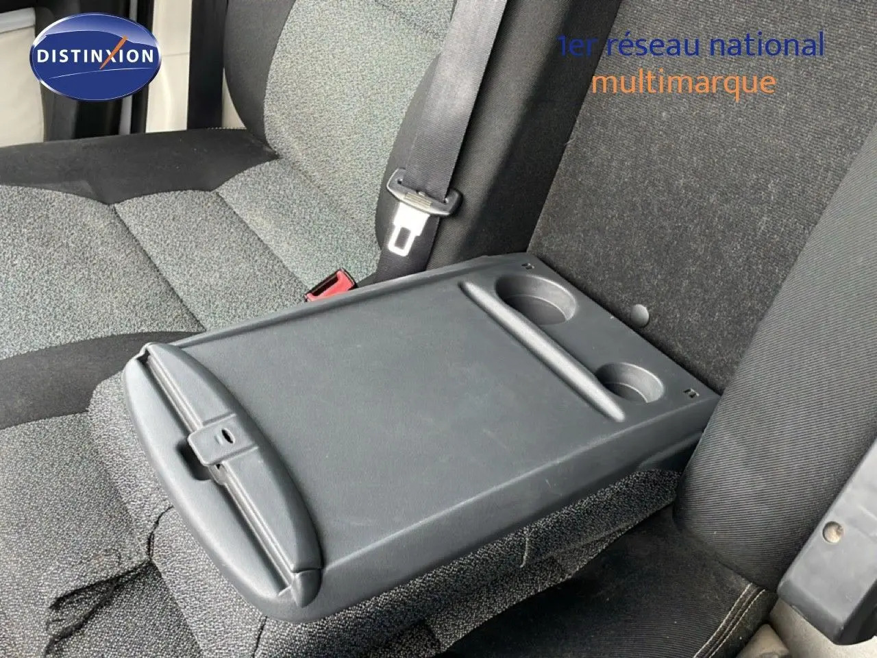 Détail de l'accoudoir central arrière avec porte-gobelets sur banquette tissu gris et noir du Fiat Ducato Fourgon blanc.