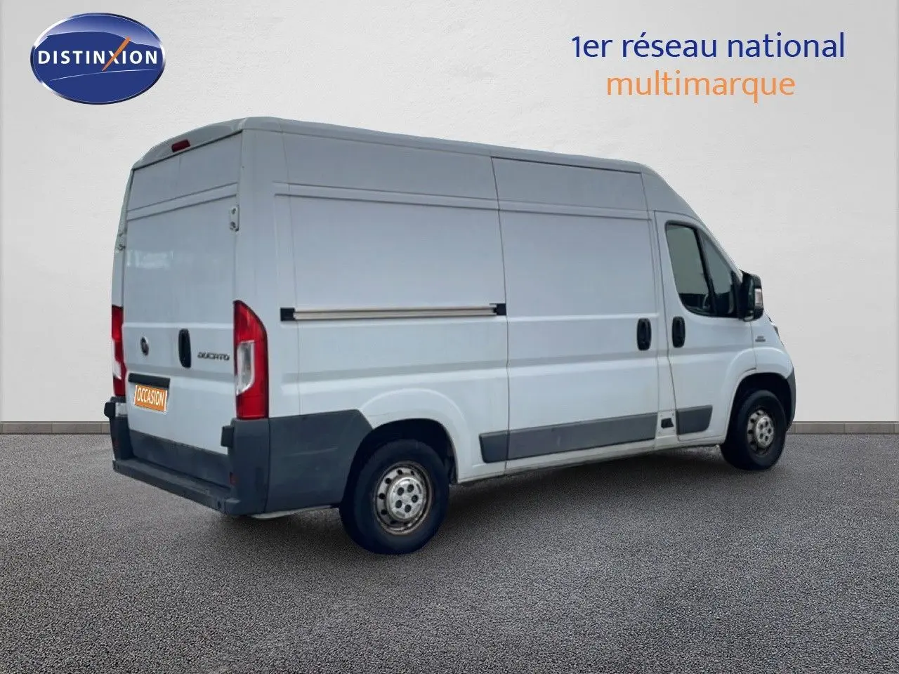 Vue 3/4 arrière droite d’un FIAT Ducato Fourgon blanc de 2014 avec porte latérale coulissante et jantes acier.