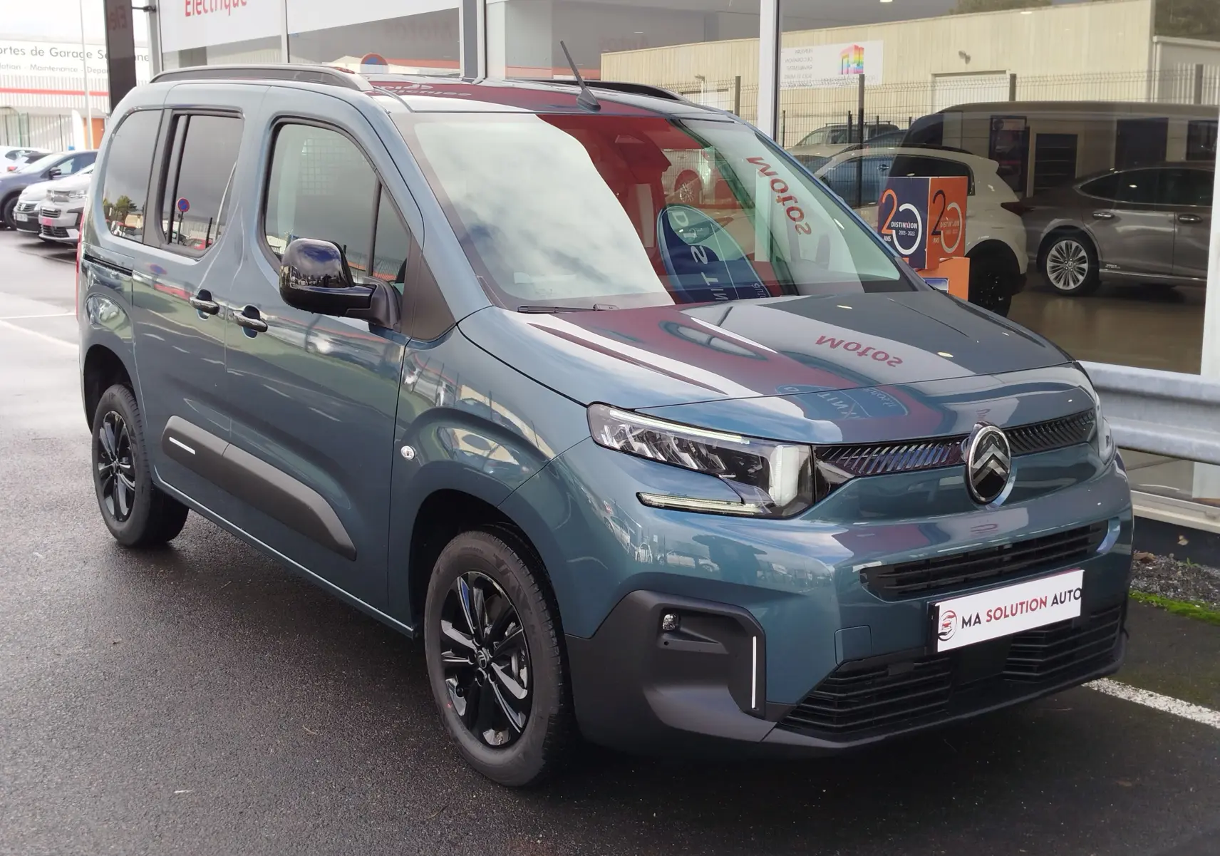 Vue 3/4 avant gauche d'un Citroën Berlingo bleu Kiarma avec jantes noires et calandre distinctive.
