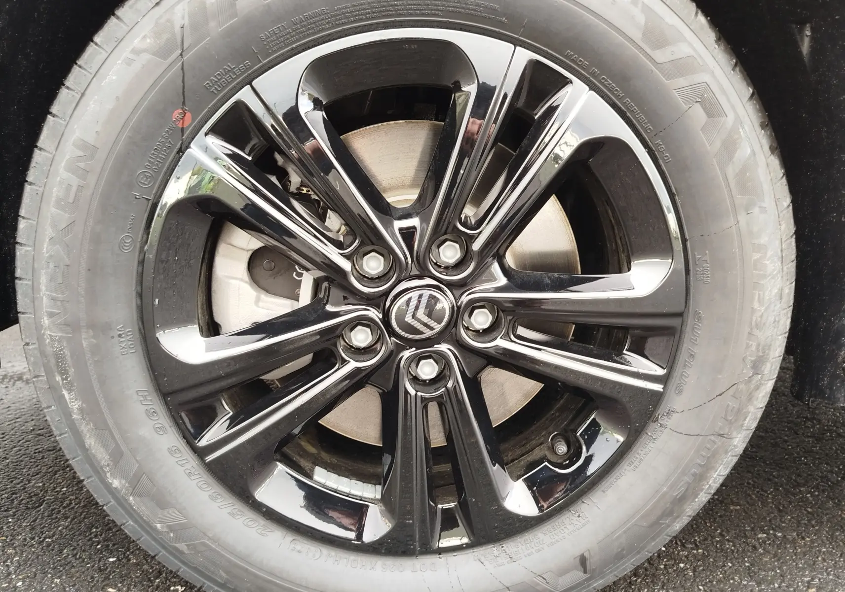 Gros plan sur la jante noire brillante d’un Citroën Berlingo 2025, mettant en valeur le logo Citroën central.