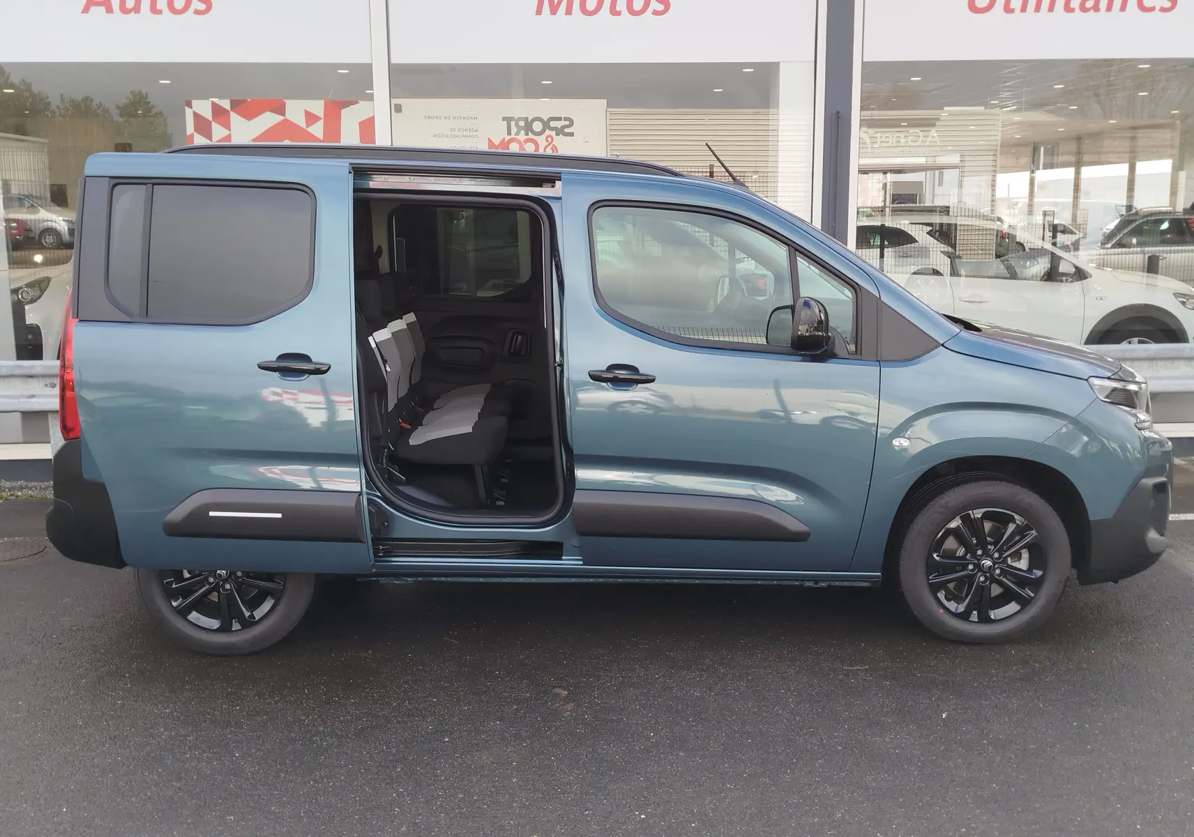 Vue de profil droit d’un Citroën Berlingo bleu Kiarma 2025 avec porte coulissante ouverte et sièges 5 places visibles.