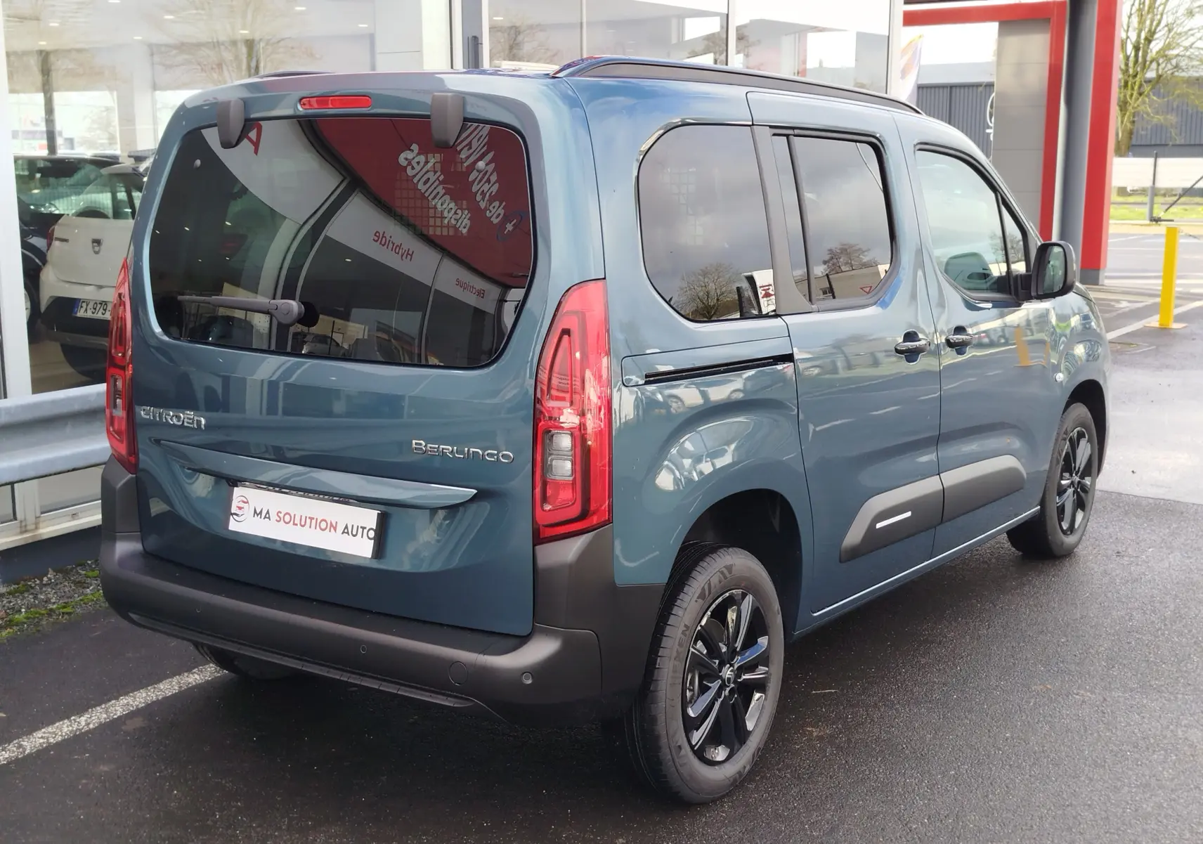 Vue 3/4 arrière droite du Citroën Berlingo 2025 bleu Kiarma avec vitres teintées et jantes noires.