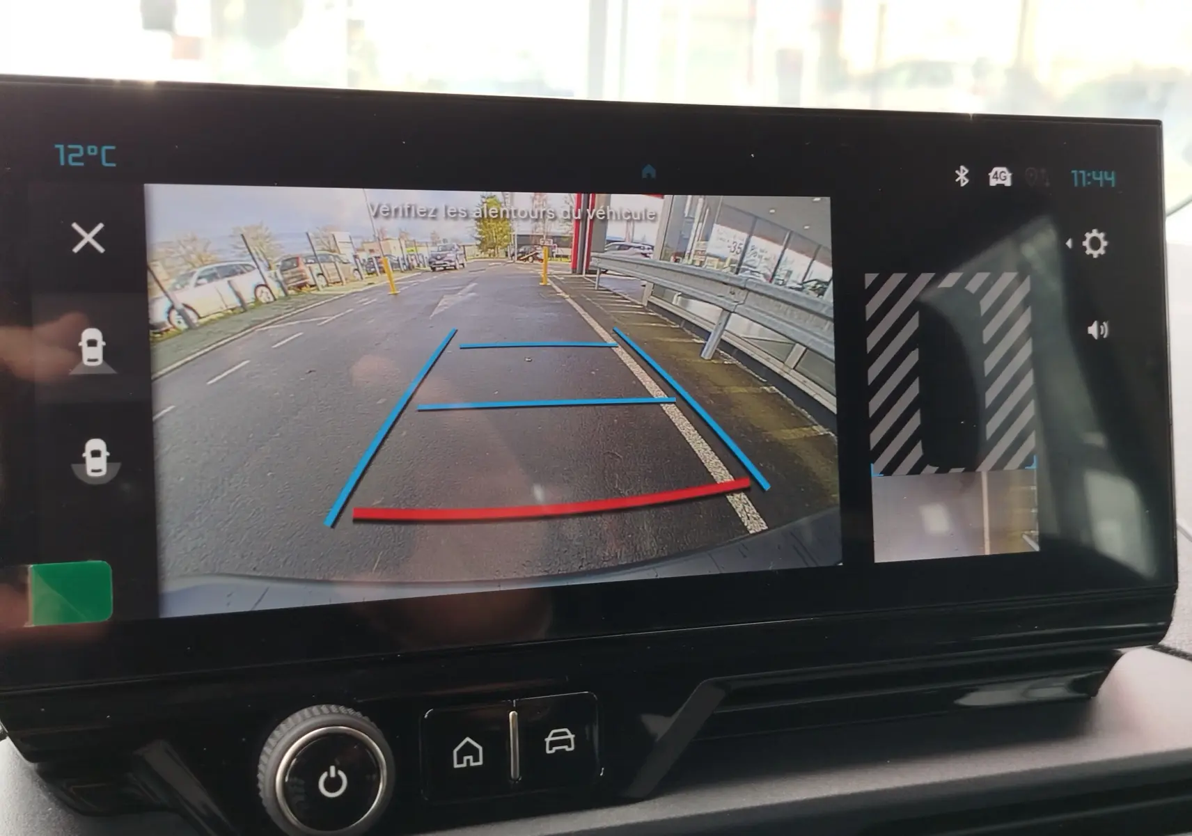 Écran de caméra de recul du Citroën Berlingo bleu Kiarma, affichant la vue arrière avec lignes de guidage colorées.