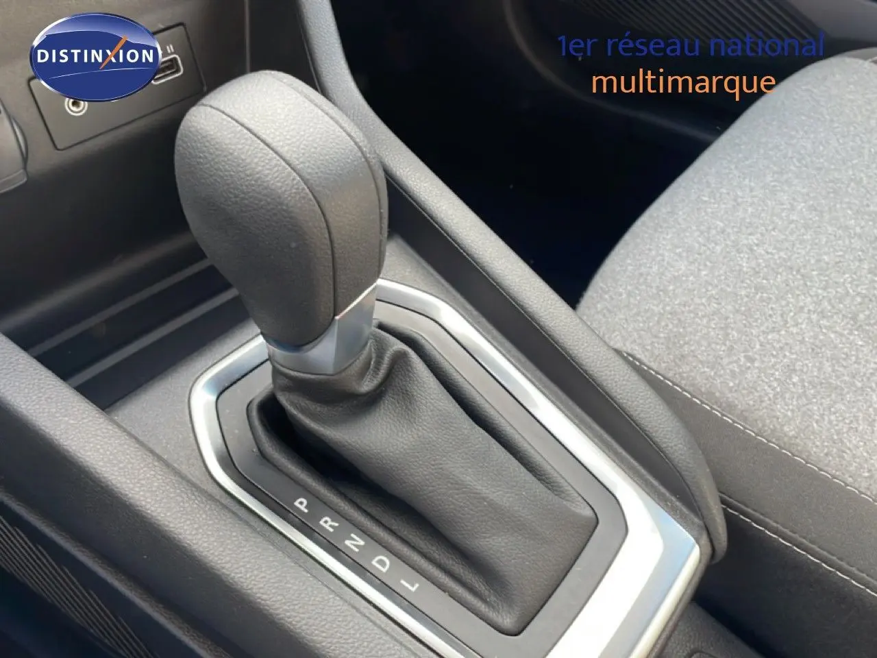 Le levier de vitesses automatique de la Renault Clio 2025, vue rapprochée de la console centrale en tissu gris.