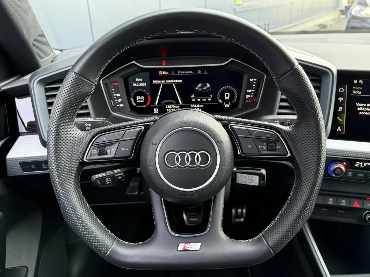 Volant sport cuir perforé avec logo S line de l'Audi A1 Sportback 30 TFSI 110 S-Tronic Competition, tableau de bord numérique visible.