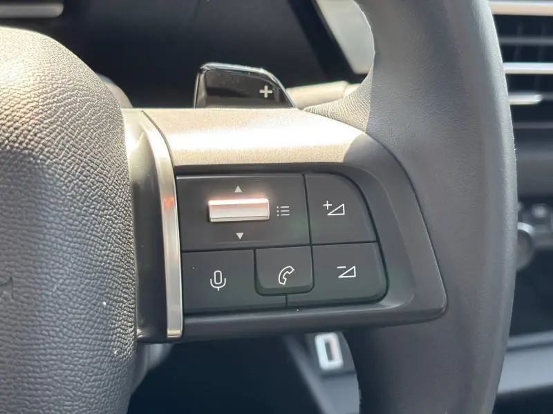 Gros plan sur les commandes multifonctions côté gauche du volant cuir du Citroën C4 X Rouge Elixir 2024.