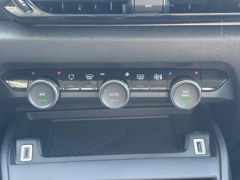 Gros plan sur les commandes de climatisation automatique noire du tableau de bord du Citroën C4 X Rouge Elixir.
