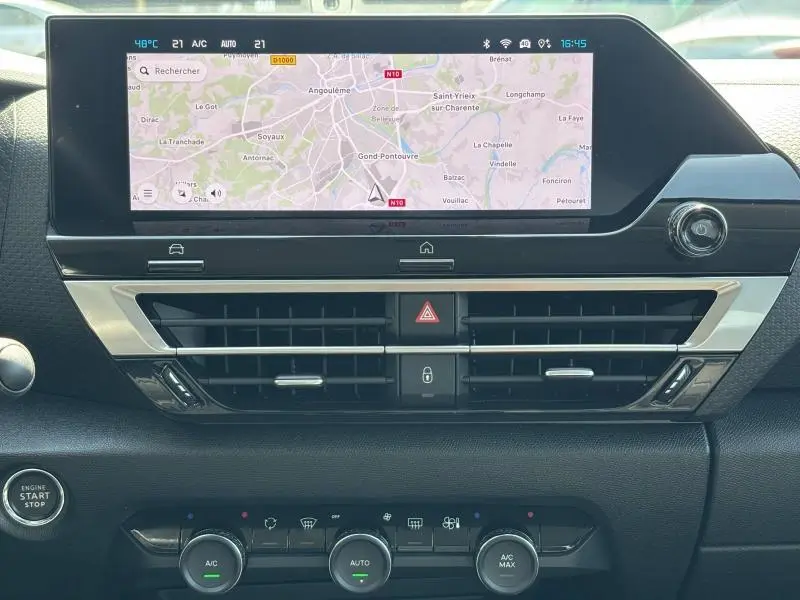 Tableau de bord de Citroën C4 X 2024 avec écran tactile GPS et commandes climatisation en vue frontale rapprochée.