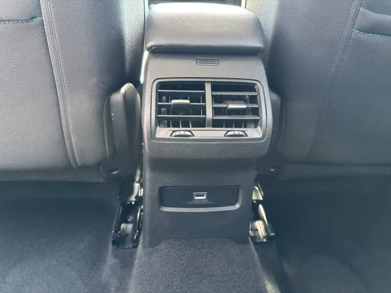 Vue rapprochée de la console centrale arrière noire avec bouches d'aération et prise USB du Citroën C4 X rouge Elixir 2024.