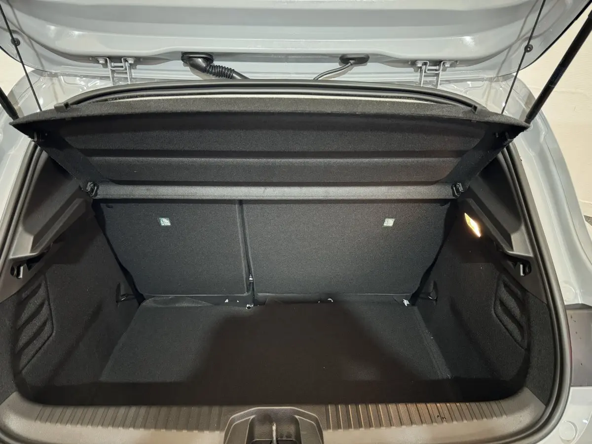 Coffre ouvert de la Renault Clio gris clair, vue arrière montrant l'espace de chargement et la tablette de séparation.