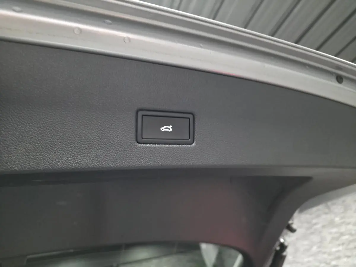 Bouton d'ouverture électrique du hayon sur la face intérieure du coffre du Volkswagen T-Roc gris 2025 R-Line.