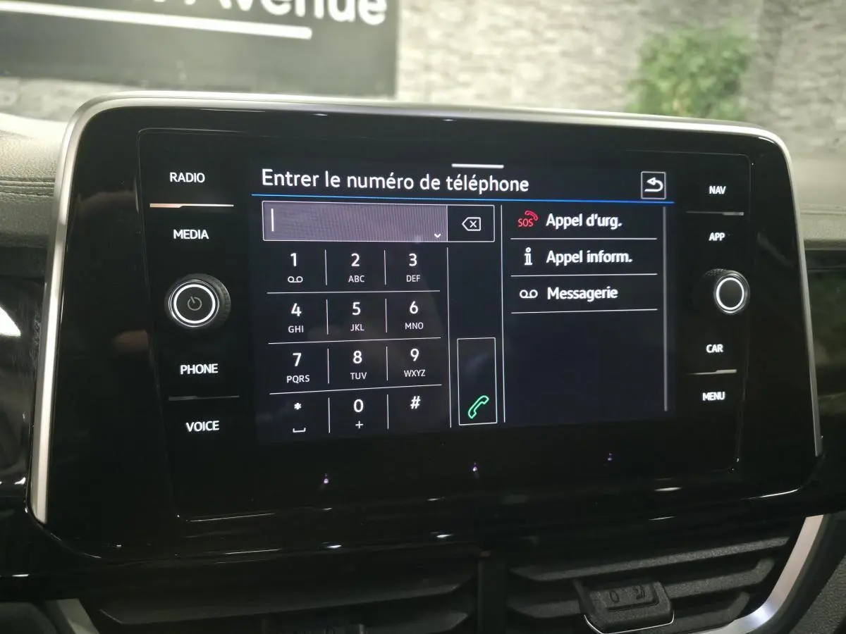Écran tactile central du Volkswagen T-Roc 2025 affichant le clavier pour entrer un numéro de téléphone.