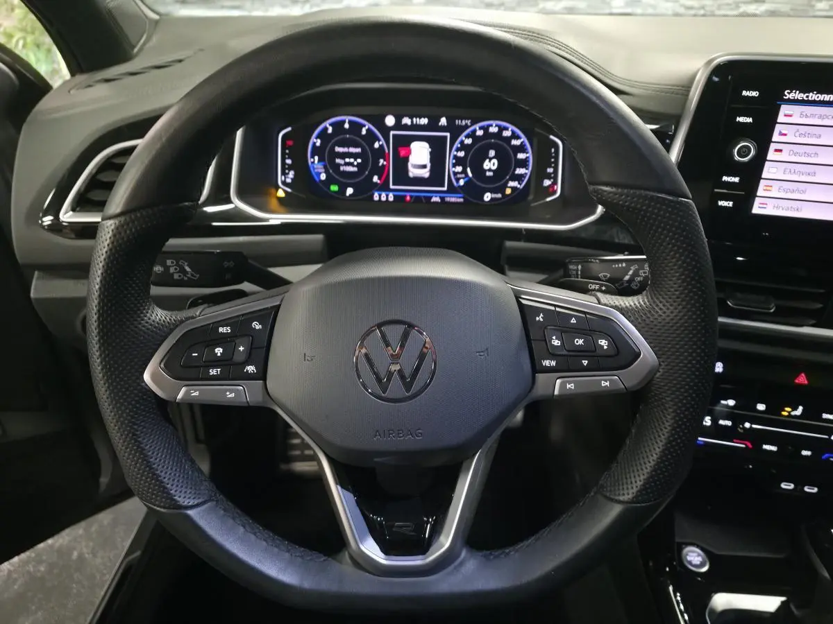 Vue rapprochée du volant noir R-Line et du tableau de bord digital du Volkswagen T-Roc 2025.