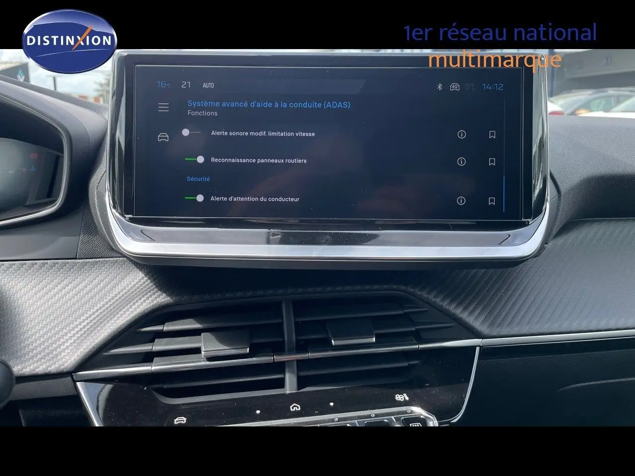 Vue rapprochée de l’écran tactile central du tableau de bord de la Peugeot 208, affichant les options d’aide à la conduite.