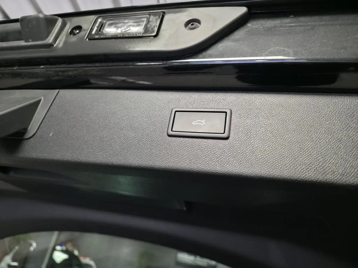 Bouton d'ouverture électrique du hayon sur la partie intérieure noire du coffre d'un CUPRA Formentor noir.