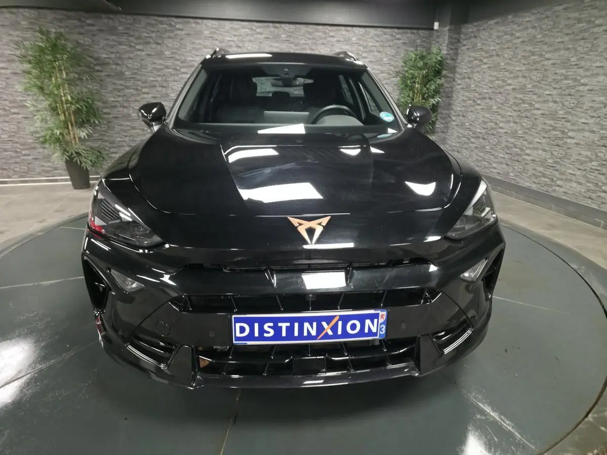 Vue avant d'une CUPRA Formentor noire 2025 avec logo cuivre et calandre imposante dans un showroom.