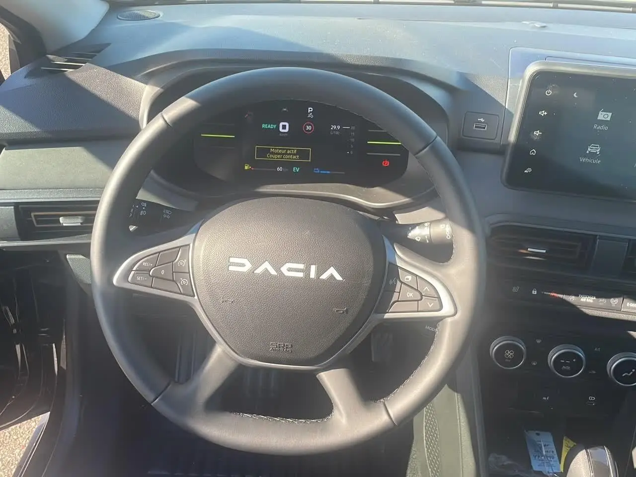 Vue frontale du volant noir du Dacia Jogger 2024 avec tableau de bord numérique et écran tactile central.