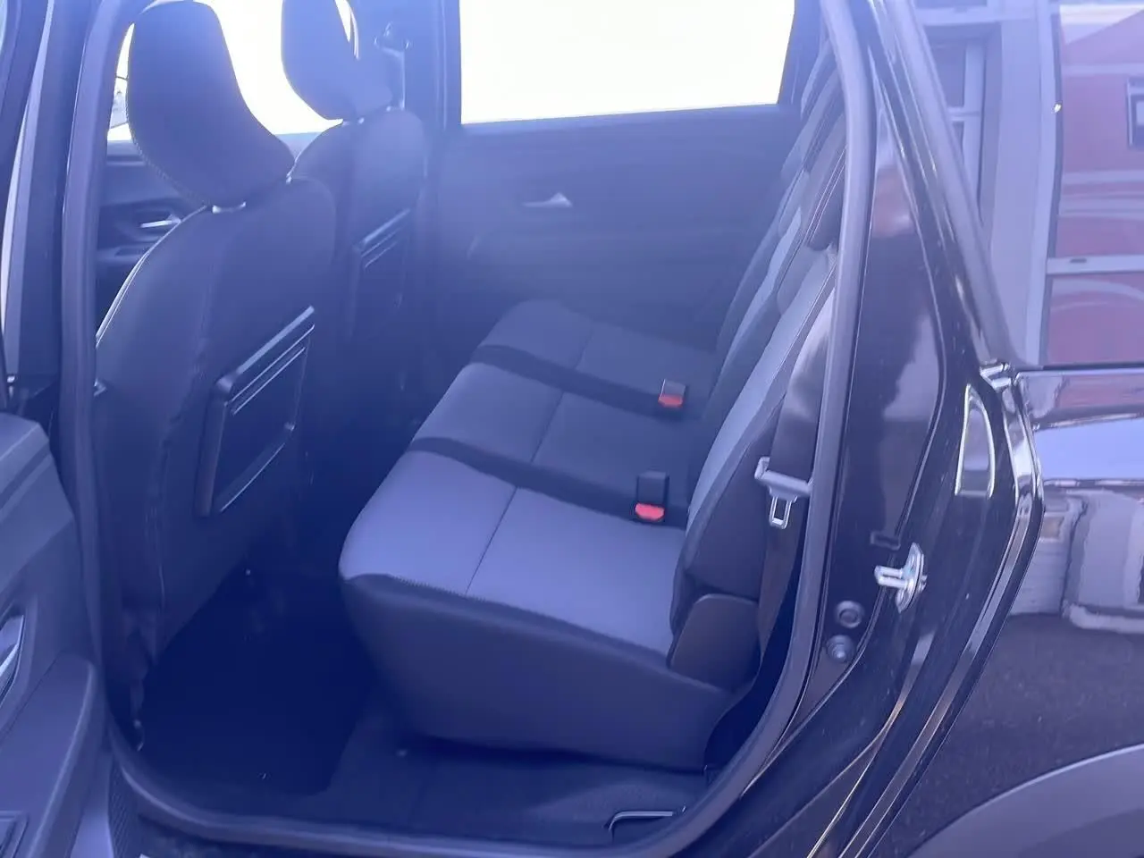 Vue côté droit sur la banquette arrière grise et noire du Dacia Jogger 1.6 hybrid noir nacré 2024 avec porte ouverte.