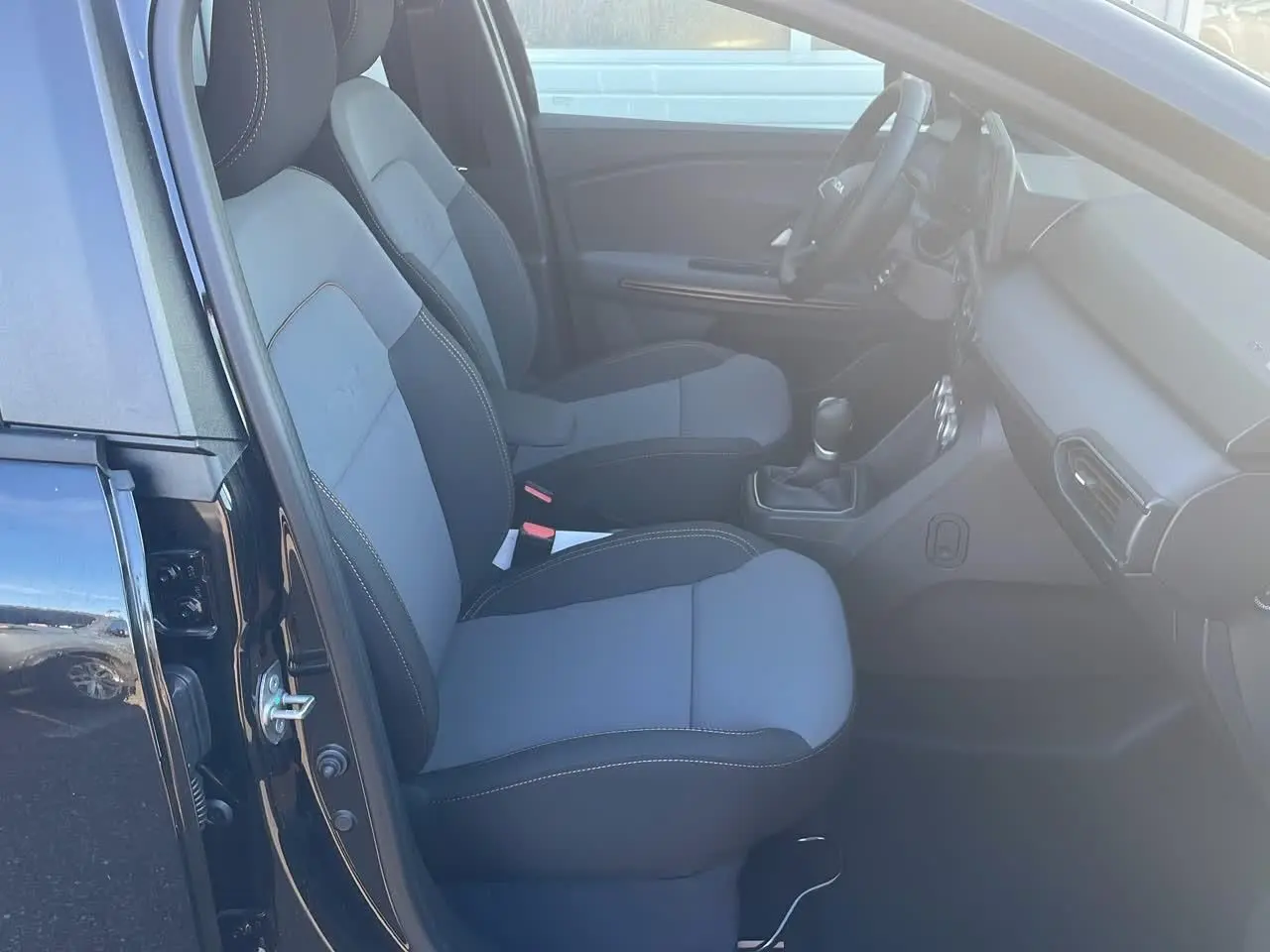 Vue côté gauche de l'intérieur du Dacia Jogger noir nacré 2024, montrant les sièges avant et le tableau de bord.