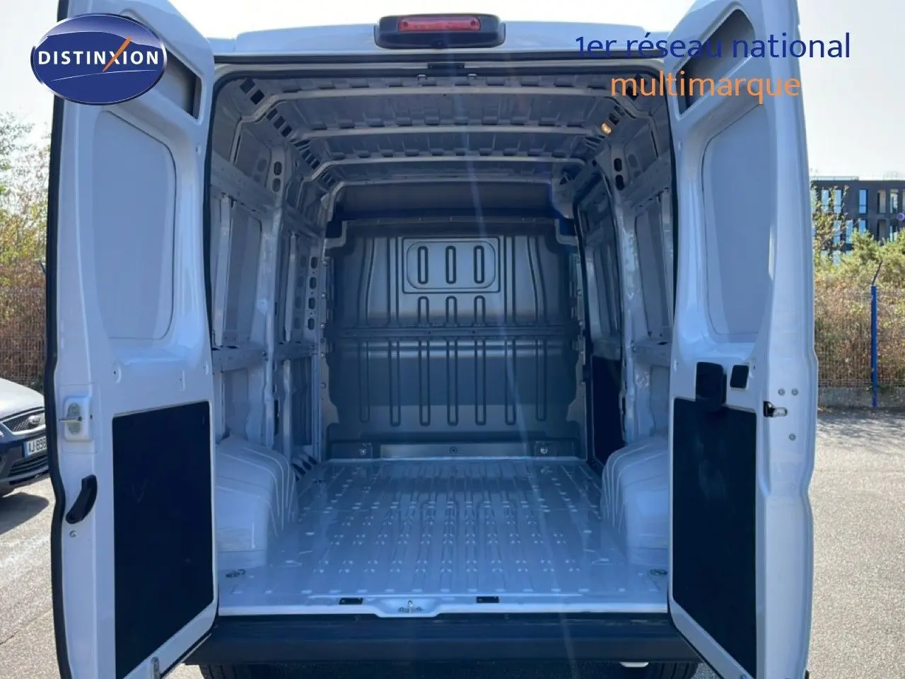 Vue arrière ouverte du Peugeot Boxer Fourgon blanc banquise 2025, montrant l'espace de chargement vide et spacieux.