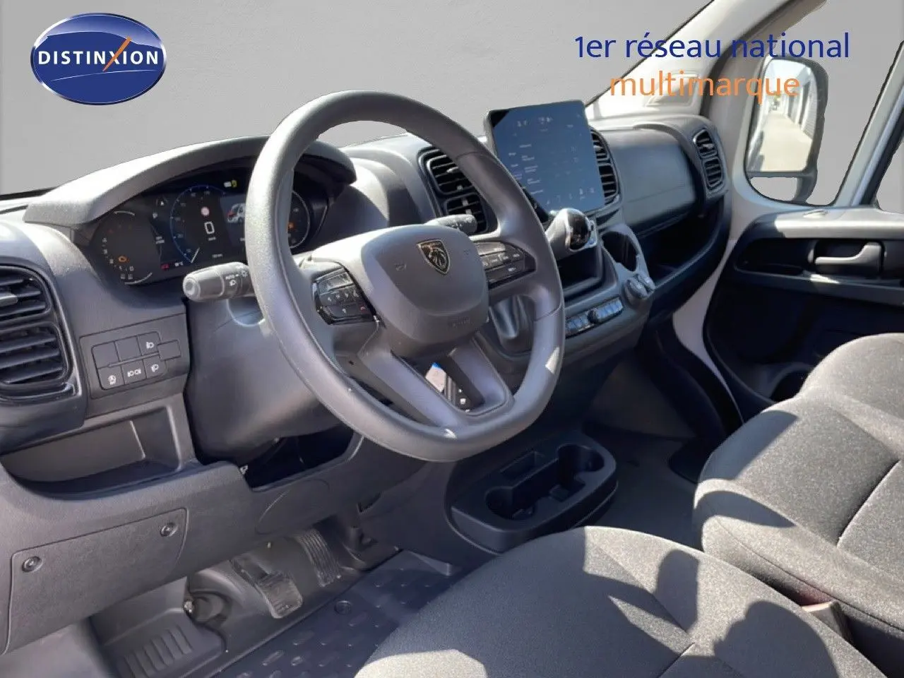 Vue intérieure côté conducteur du Peugeot Boxer Fourgon 2025, tableau de bord moderne avec écran tactile et volant multifonction.