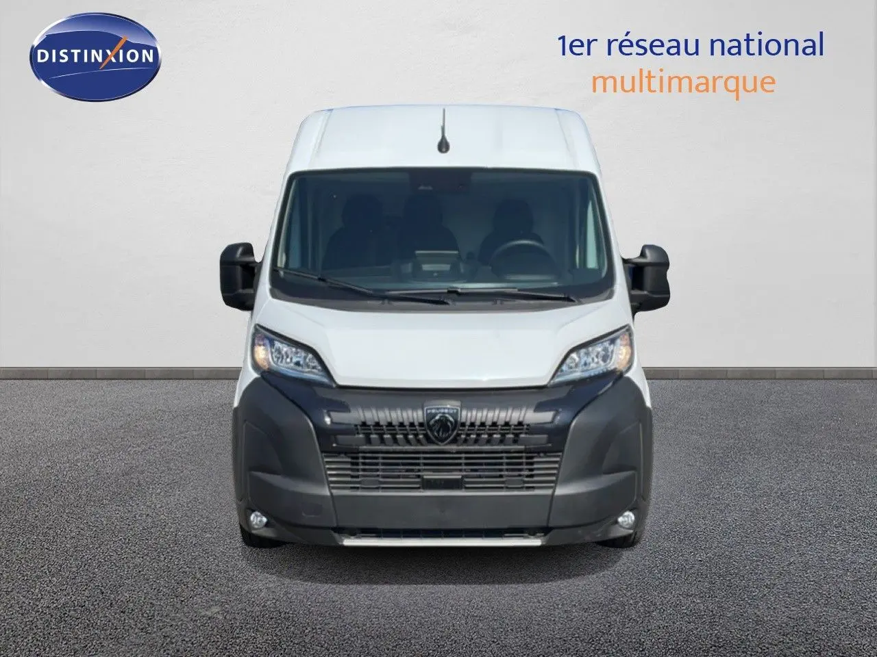 Vue frontale du Peugeot Boxer Fourgon blanc banquise, avec calandre noire et phares modernes allumés.