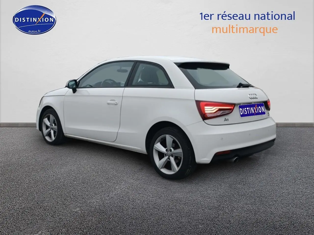 Audi A1 blanc vue 3/4 arrière côté gauche, feux arrière LED et jantes alliage visibles.