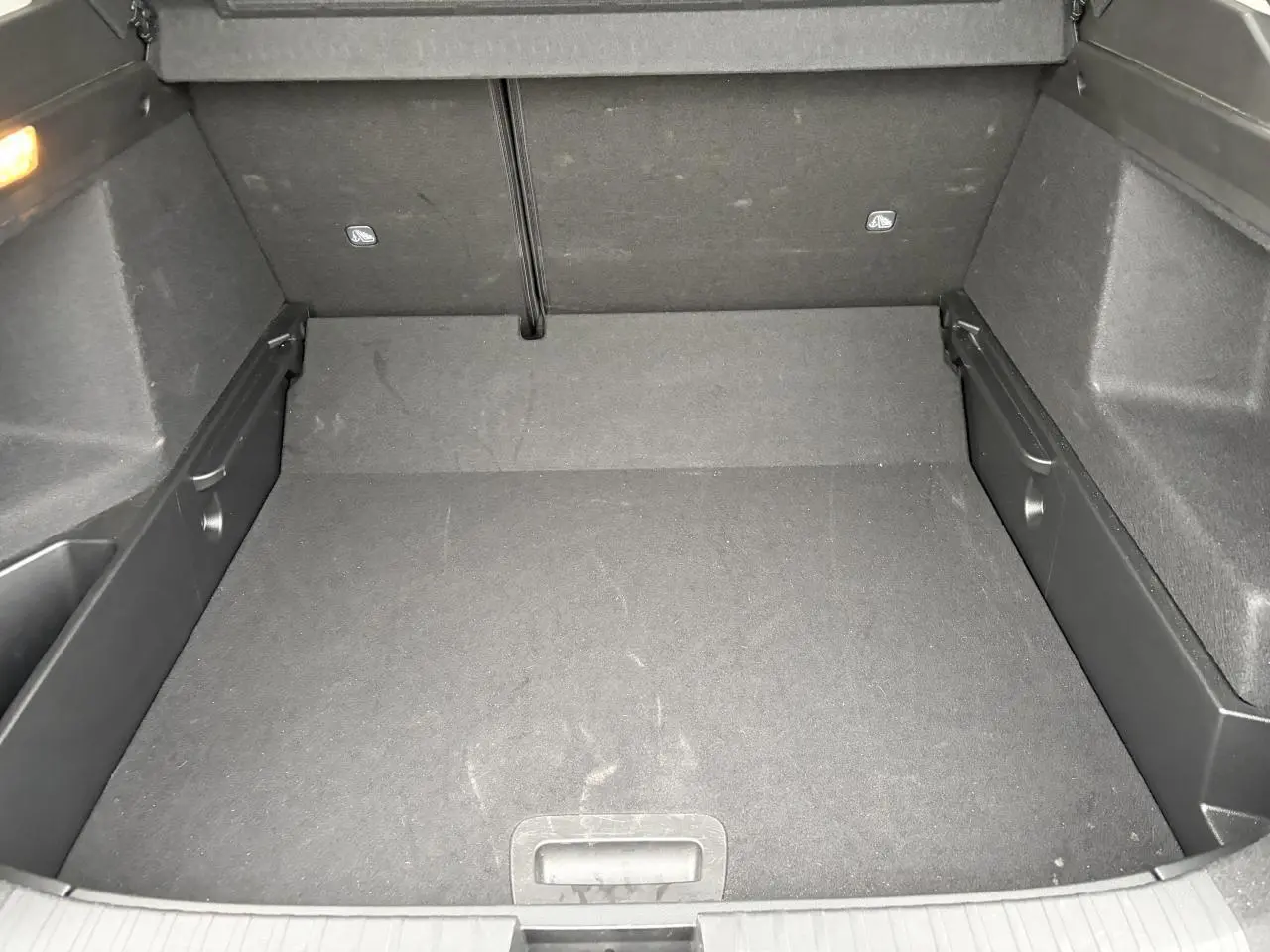 Coffre vide vu de face, plancher plat et revêtement noir, intérieur spacieux du Renault Arkana Bleu Zanzibar 2025.