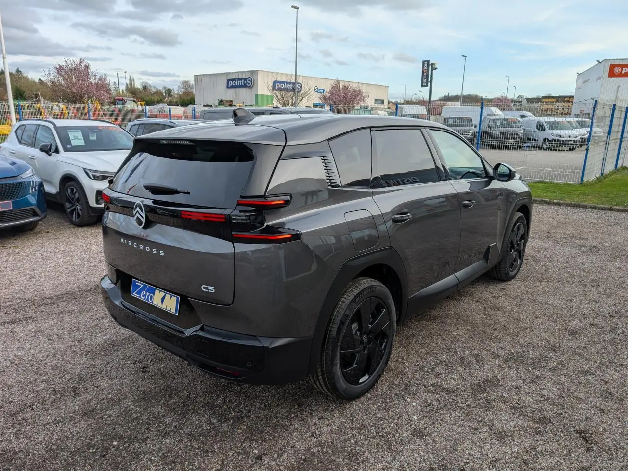 Vue 3/4 arrière droite du Citroën C5 Aircross gris avec feux arrière LED fins et jantes alliage noires.