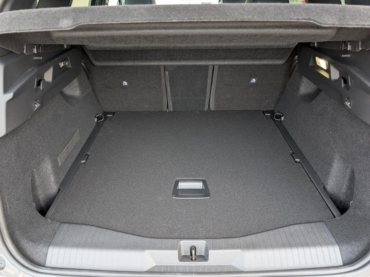 Vue intérieure du coffre spacieux et propre du Citroën C5 Aircross gris, avec éclairage latéral allumé.