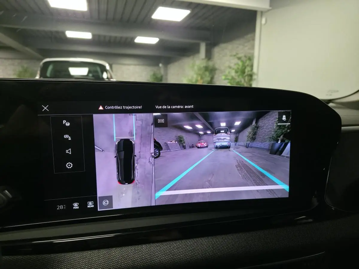 Écran intérieur affichant la caméra avant et vue 360° d'une Audi A5 Avant noire en parking couvert.