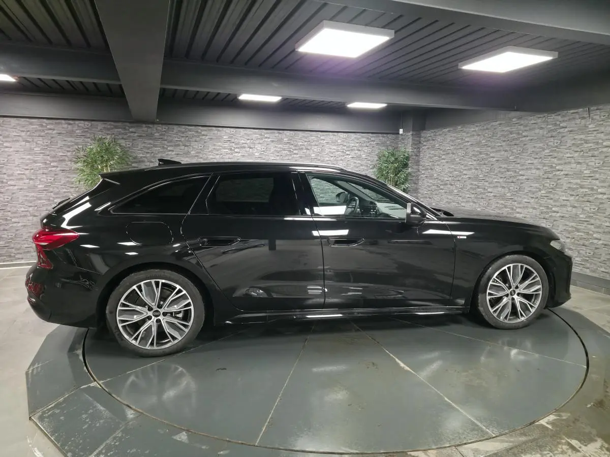 Audi A5 Avant 2025 noir vue de profil côté gauche, jantes 19 pouces et vitres arrière surteintées visibles.