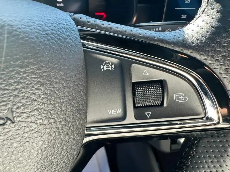 Gros plan sur les commandes noires du volant cuir perforé du Skoda Kamiq 2020, avec boutons de vue et navigation.