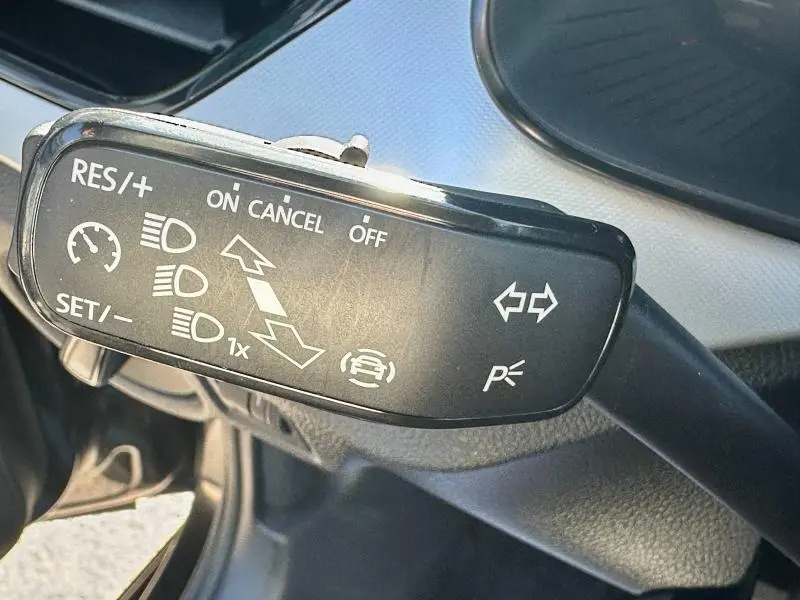 Gros plan sur la commande de régulateur de vitesse et clignotants du Skoda Kamiq 2020, intérieur noir et gris.