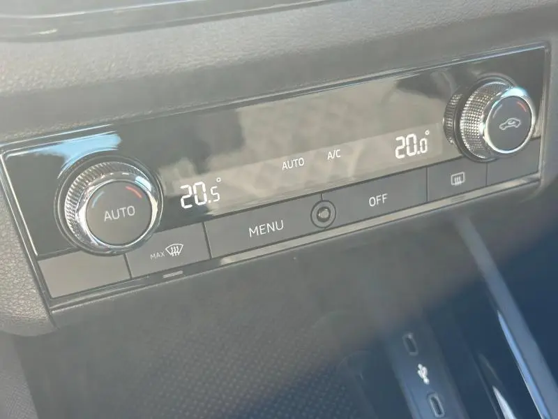 Gros plan sur la commande de climatisation automatique du Skoda Kamiq 2020, affichant 20°C, avec boutons rotatifs chromés.