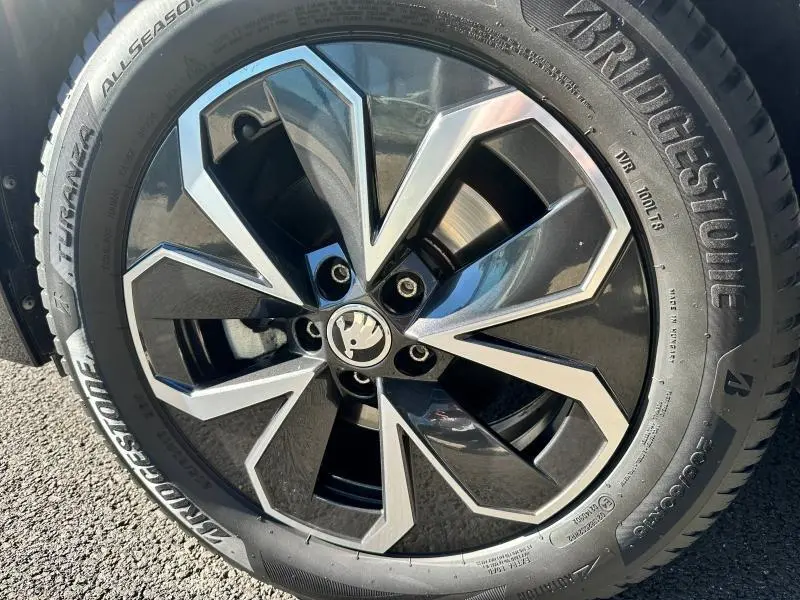 Gros plan sur la jante alu noire et argentée d’un Skoda Kamiq 2020 avec pneu Bridgestone all season.