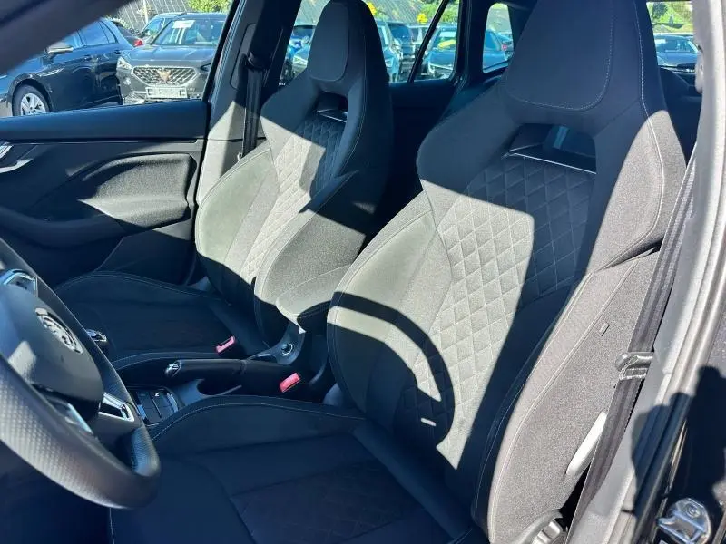 Intérieur avant du Skoda Kamiq 2020 essence, sièges noirs avec surpiqûres losanges et volant cuir multifonction visible