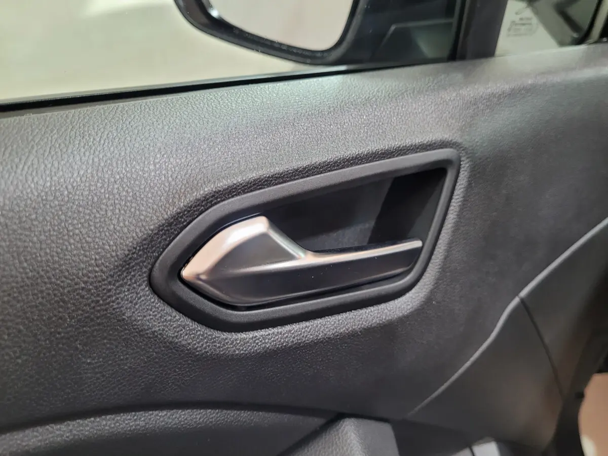 Poignée intérieure de porte côté conducteur de Renault Clio gris foncé, avec texture noire et insert argenté.