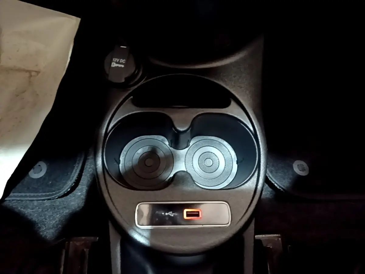 Gros plan sur la console centrale noire de la Fiat 500 Lounge 2019 avec porte-gobelets et prise USB rouge.