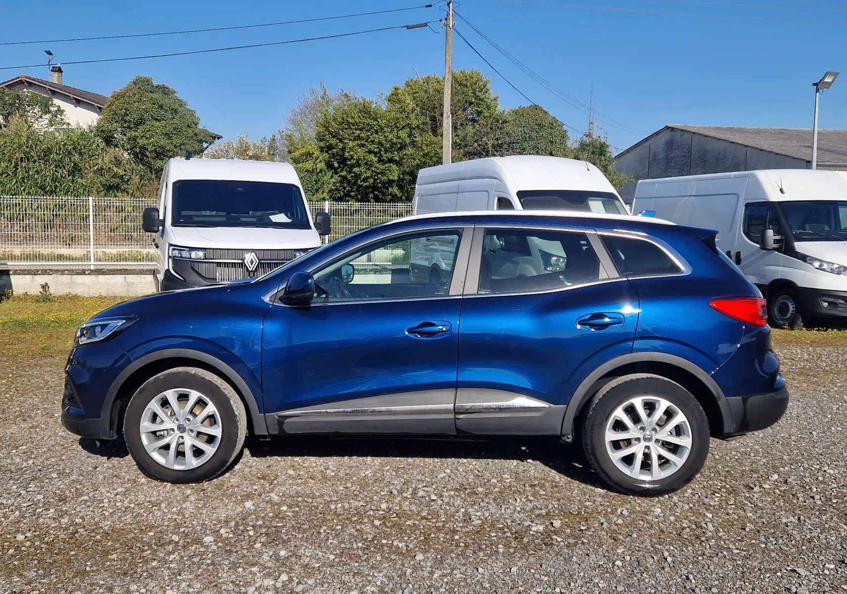 Profil droit d’un Renault Kadjar bleu cosmos 2020, SUV compact avec jantes alliage et détails noirs sur bas de caisse.